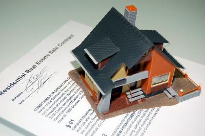small model house on top of real estate contract