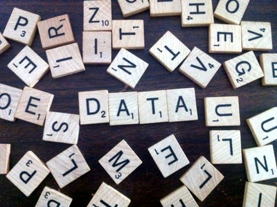Data spelled out by Scrabble pieces amidst random pieces